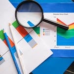 Image of financial charts and magnifying glass, ideal for business insights.